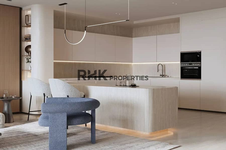 7 Modern open kitchen with fluted island pendant lighting and blue boucle armchair Dubai apartment