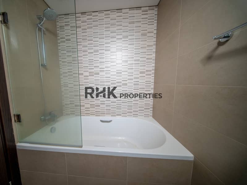 5 Contemporary bathroom featuring bathtub with shower, glass partition and stylish tiled walls