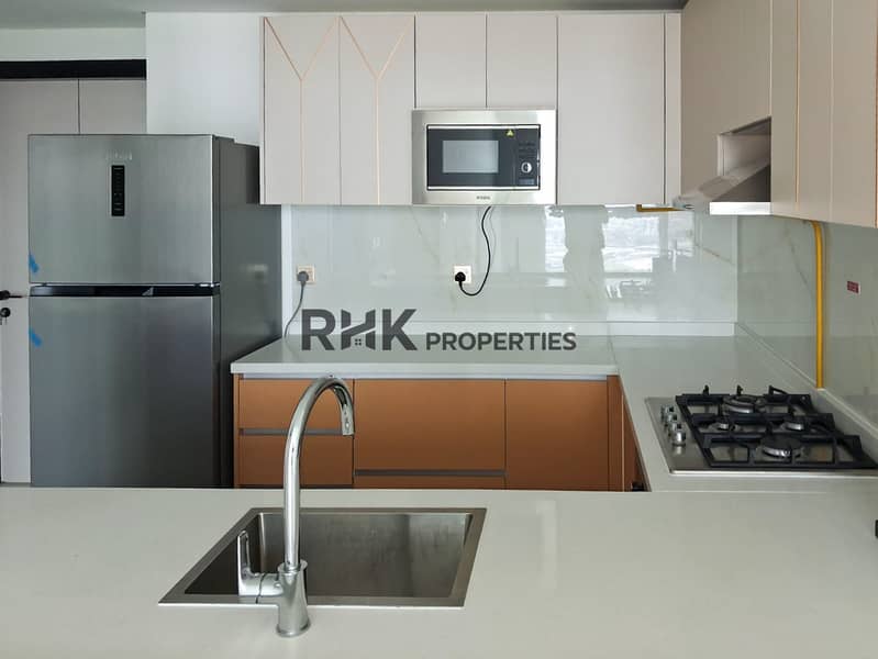 9 Modern fitted kitchen with stainless steel sink, gas hob and fridge in Dubai apartment