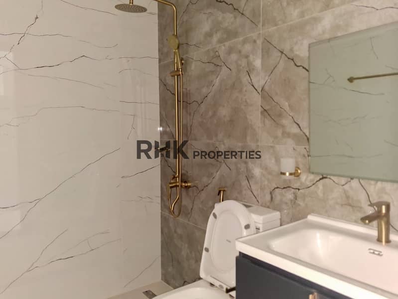 16 Second bathroom with grey marble wall tiles, gold shower column and wall-hung navy vanity