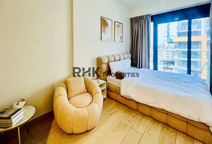 5 Cozy sleeping area with boucle armchair and balcony in a short term rental studio, MBR City Dubai