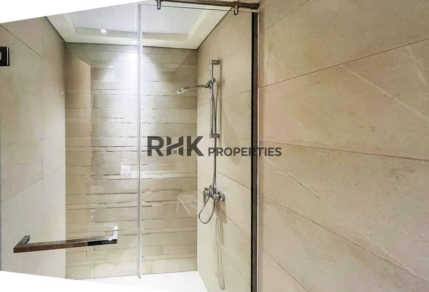 11 Walk-in glass shower with stone feature wall in a modern Meydan Dubai apartment bathroom