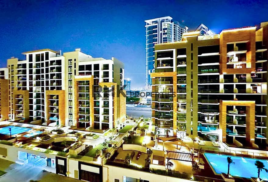 12 Azizi Riviera Meydan residential community at night with swimming pools and landscaped courtyards
