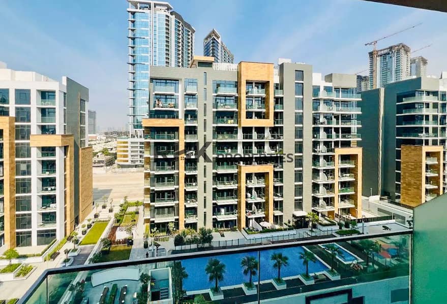 13 Daytime view of Azizi Riviera apartment buildings and community pool in Meydan, Mohammed Bin Rashid City