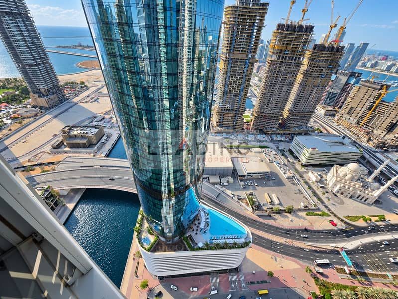 12 Curved Glass Tower Above a Turquoise Pool. png