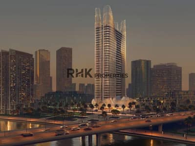 Studio te Koop in Business Bay, Dubai - Luxury residential tower with illuminated twin spires at dusk on Dubai waterfront with palm-lined boulevard Studio te Koop in Business Bay, Dubai - Luxury residential tower with illuminated twin spires at dusk on Dubai waterfront with palm-lined boulevard