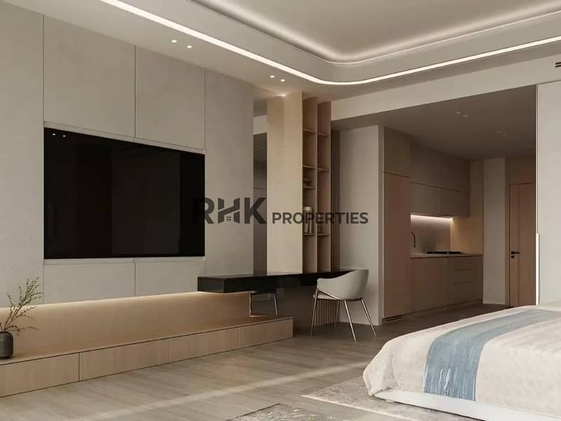 7 Modern luxury studio apartment interior with integrated wooden kitchenette, built-in TV wall unit, cove lighting and walk-in wardrobe in Dubai high-rise
