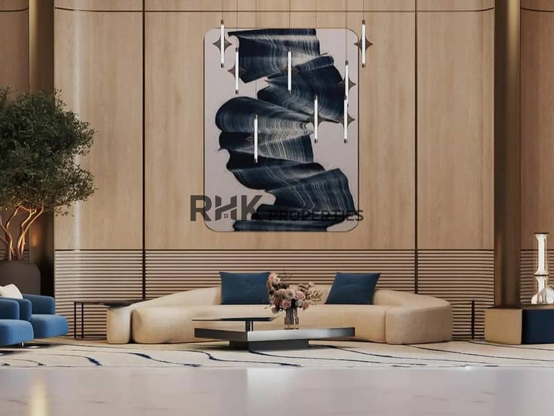 10 Grand residential tower lobby lounge with floor-to-ceiling timber panel walls, large abstract artwork, curved cream sofa and navy accent chairs in Dubai luxury development