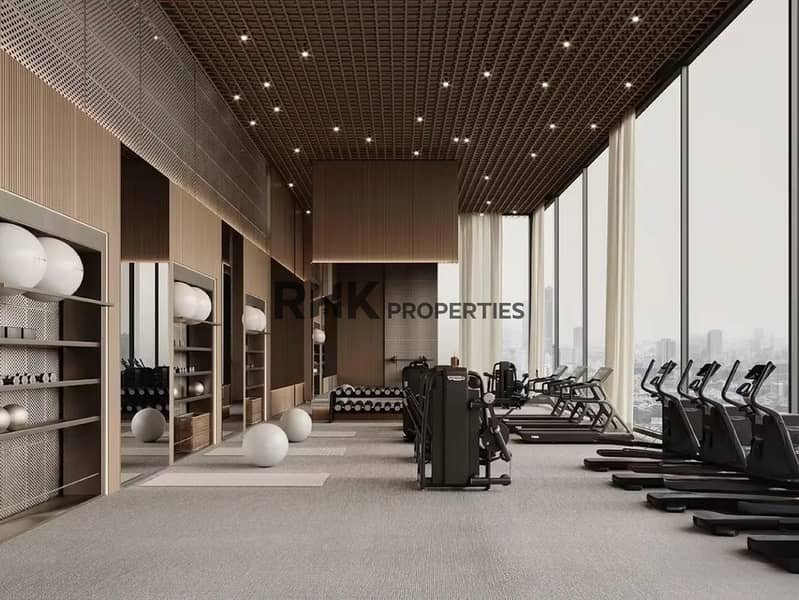 12 State-of-the-art residents gym with floor-to-ceiling windows overlooking Dubai skyline, treadmills, cable machines and free weights in luxury residential tower