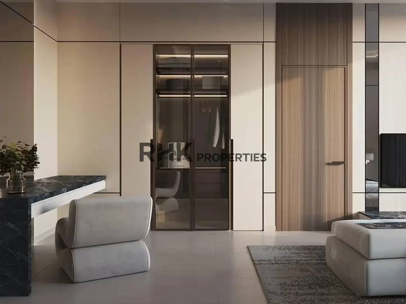 6 Modern luxury bedroom with padded fabric headboard, fluted timber feature wall, abstract canvas artwork, sitting sofa and gold accent wall lights in Dubai apartment