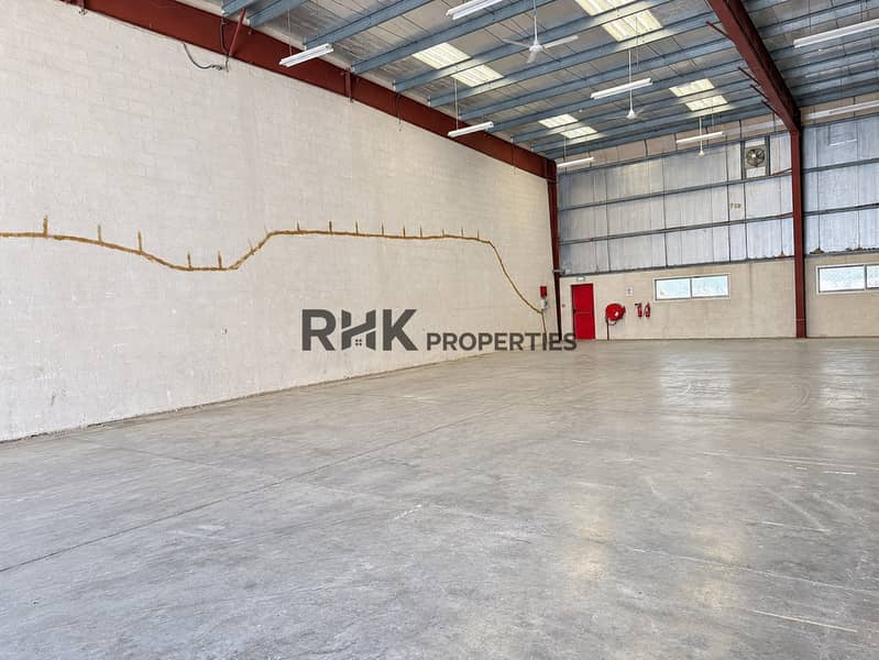 5 Spacious vacant commercial warehouse with high ceilings, concrete flooring, steel beams and fire-safety equipment.