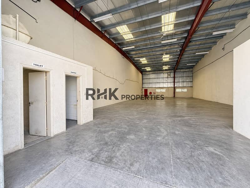 4 Wide view of vacant industrial warehouse with high roof, open floor space, pantry and toilet facilities.