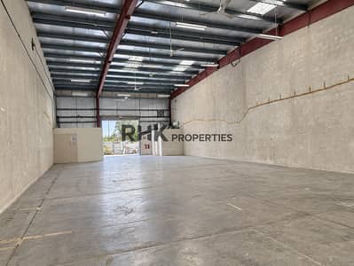 迪拜投资园区（DIP）， 迪拜 仓库待租 - Large commercial warehouse interior with clear-span floor space, high steel roof and loading access.
