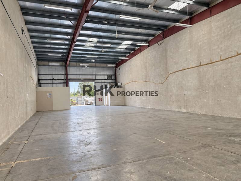 Large commercial warehouse interior with clear-span floor space, high steel roof and loading access. Large commercial warehouse interior with clear-span floor space, high steel roof and loading access.