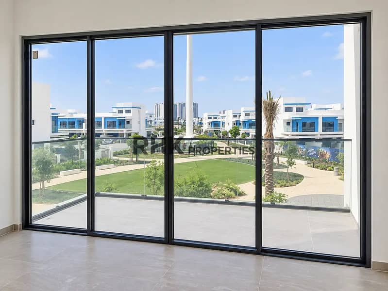 5 Spacious living room in Dubai villa with floor-to-ceiling sliding glass doors overlooking community park and palm trees