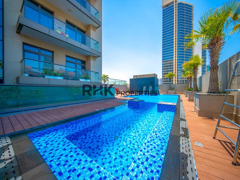 Luxury residential pool area surrounded by modern apartments and landscaped outdoor spaces Luxury residential pool area surrounded by modern apartments and landscaped outdoor spaces