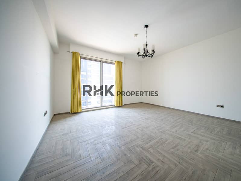 2 Bright unfurnished apartment living area with large window, modern flooring and abundant natural light