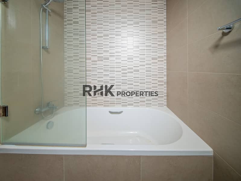 7 Contemporary bathroom featuring bathtub with shower, glass partition and stylish tiled walls