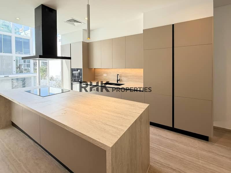 6 Contemporary luxury townhouse kitchen with large island, built-in appliances, modern cabinetry and stone worktops
