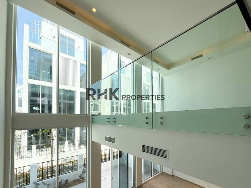 7 Modern luxury townhouse double-height living room with floor-to-ceiling windows and glass staircase