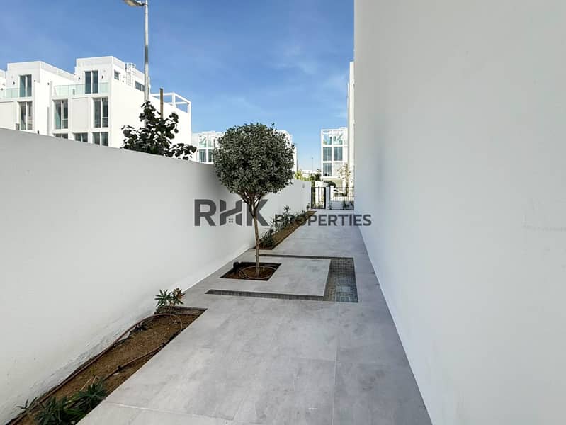 10 Private landscaped townhouse garden with tiled pathway, mature topiary tree and gated outdoor space