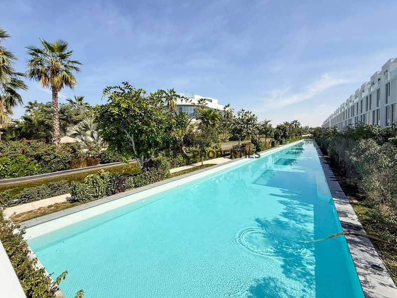11 Luxury residential community with landscaped gardens and long outdoor swimming pool surrounded by townhouses