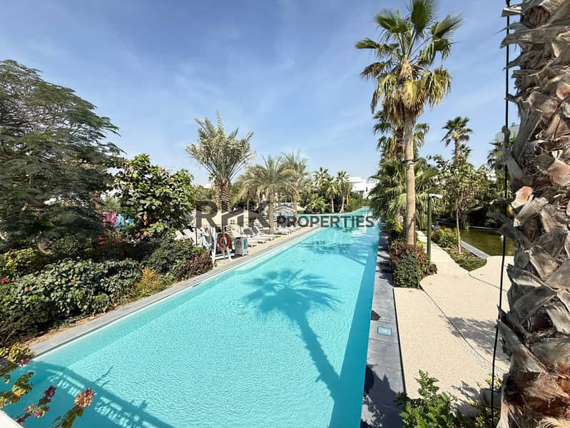 13 Resort-style residential swimming pool with sun loungers, palm trees and landscaped garden surroundings