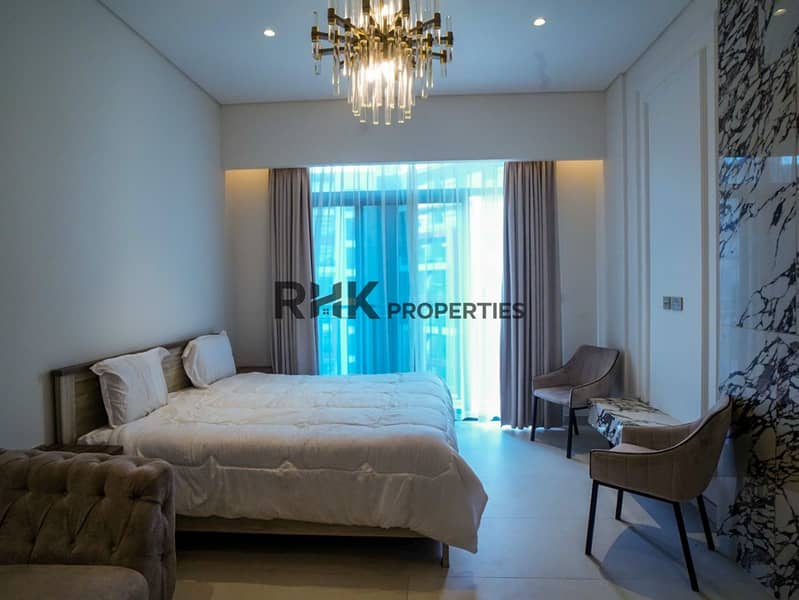2 Bright studio bedroom area with floor-to-ceiling windows and balcony access at Floarea Residence Dubai