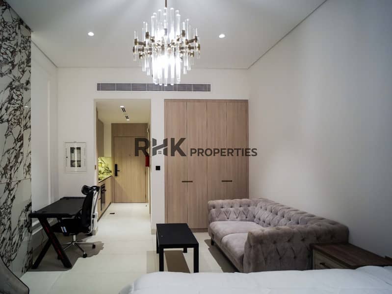 4 Studio apartment layout showing entrance, kitchenette, work desk, wardrobe and sofa in Dubai
