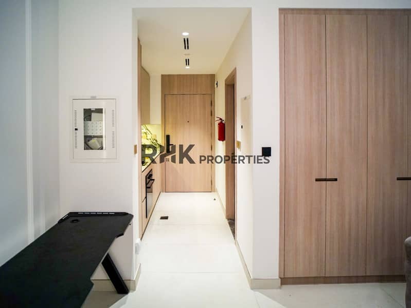 7 Furnished studio apartment entrance with built-in wooden wardrobe and kitchenette at Floarea Residence