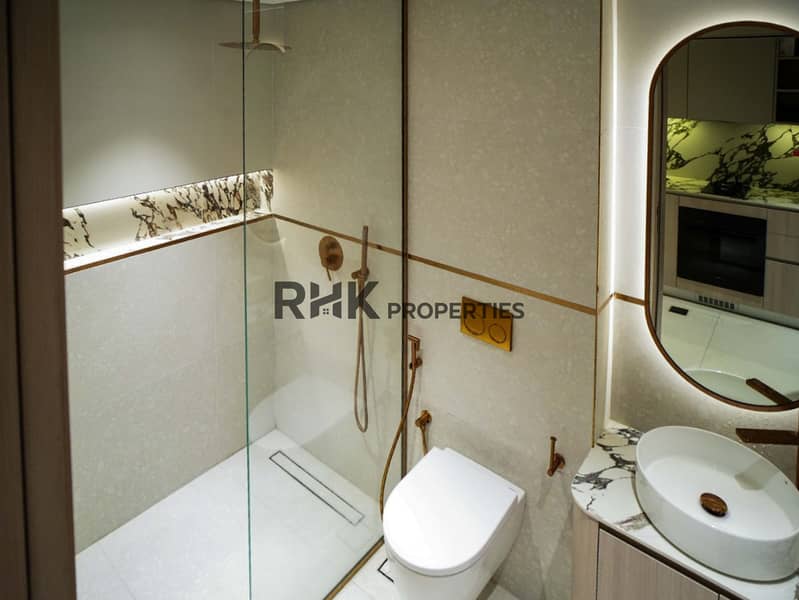 11 Studio bathroom with walk-in glass shower, wall-hung toilet and bidet spray at Floarea Residence