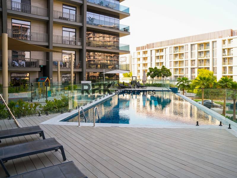 13 Outdoor swimming pool with wooden deck and sun loungers at Floarea Residence apartments in Dubai