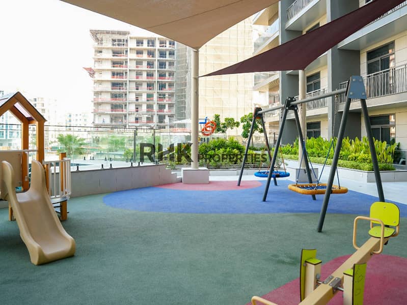 15 Shaded kids' playground with swings, slide and seesaw at Floarea Residence apartment complex in Dubai