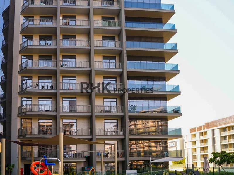 16 Building facade with private balconies overlooking pool and kids' play area at Floarea Residence Dubai