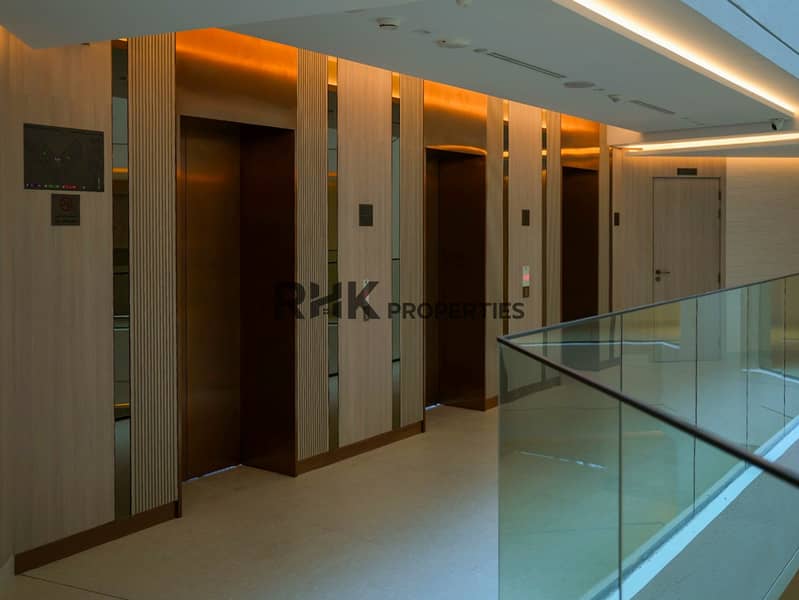17 Modern elevator lobby with wood-panel walls and glass railing at Floarea Residence Dubai