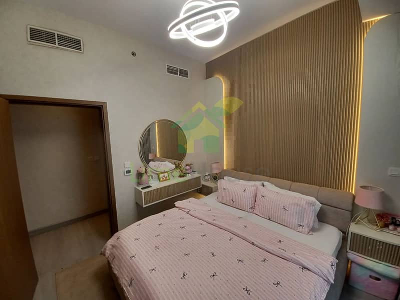 29 dubai-marina-bedroom-modern-chandelier-wood-panel-floating-vanity-round-mirror. webp
