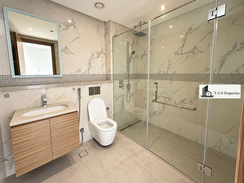 17 Modern Marble-Tile Bathroom with Glass Shower. png