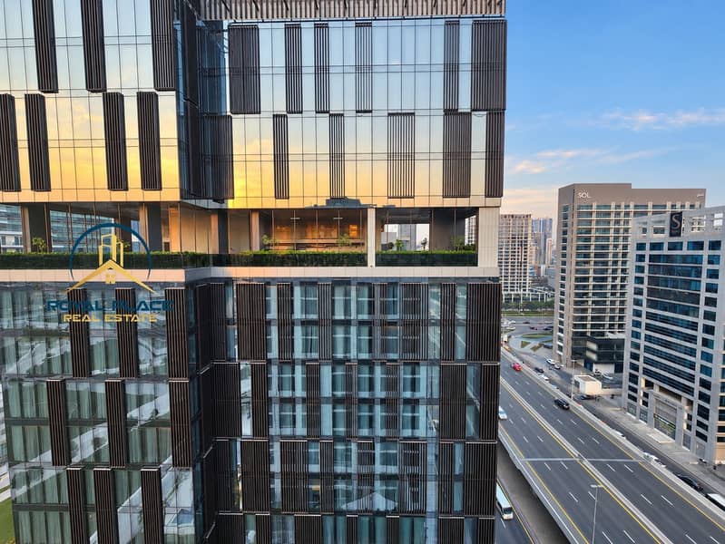 12 Sunset-lit glass tower from apartment window. png