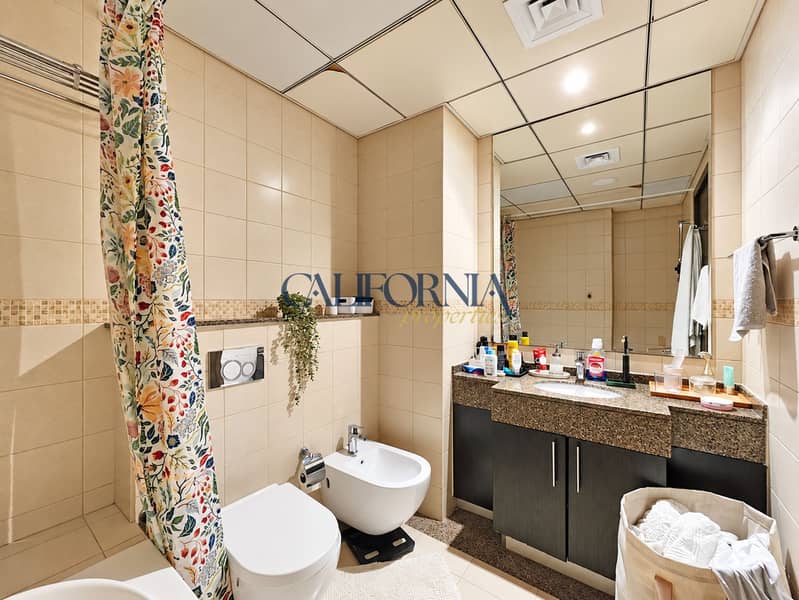9 Bright tiled bathroom with floral curtain. png