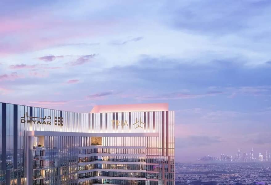 12 Tower exterior at dusk with "DEYAAR" and "TRIA" signage lit up against a pink and blue sky.