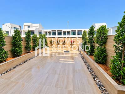 4 Bedroom Townhouse for Sale in DAMAC Hills, Dubai - Modern Courtyard Garden Under Blue Skies. png
