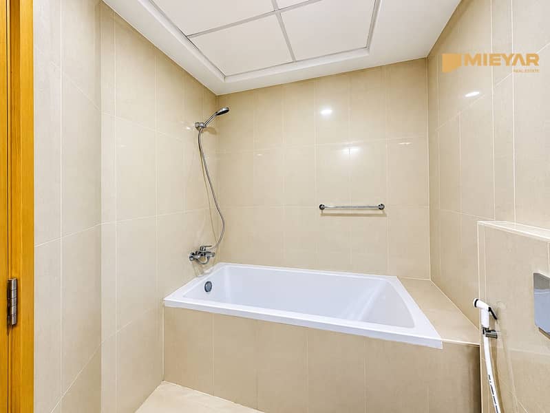 9 Bright Beige Tiled Bathroom with Bathtub. png