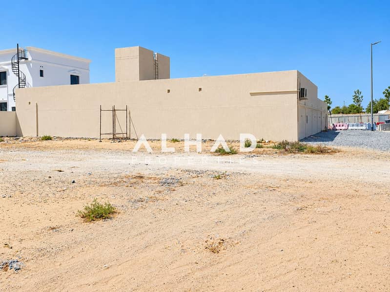 5 Sunny Sandy Lot with Beige Stucco Wall. png