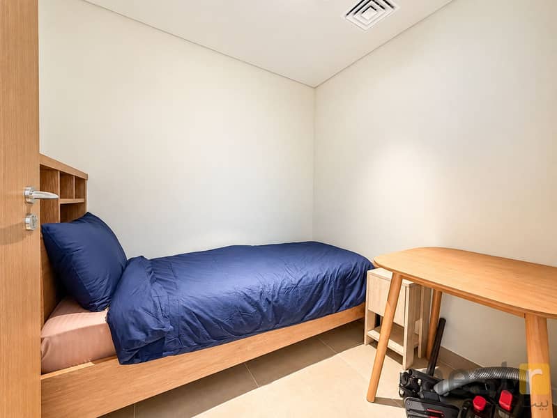16 Minimalist Bedroom with Navy Bedding and Vacuum. png