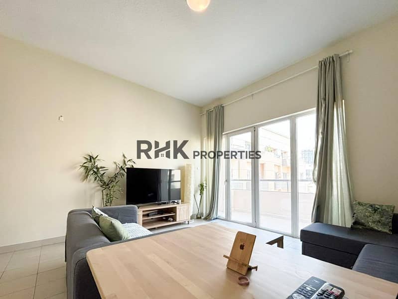 2 Bright apartment living room with gray sofas, TV unit, coffee table and large glass balcony doors