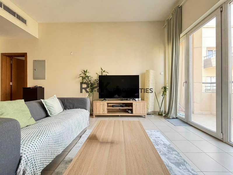 3 Modern apartment living room with gray sofa, wooden coffee table, TV and large balcony windows