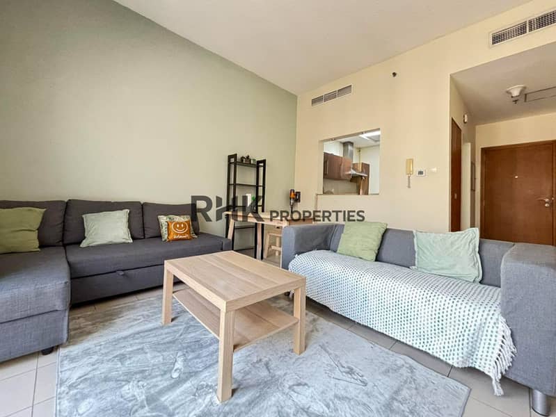 4 Spacious apartment lounge with gray sectional sofas, wooden coffee table and open kitchen area