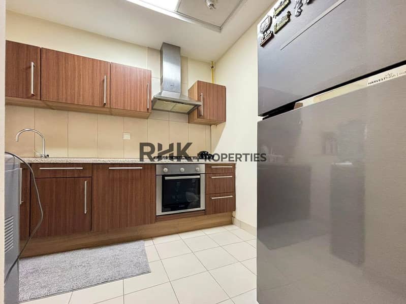 7 Modern apartment kitchen with wooden cabinets, built-in oven, gas stove and stainless steel refrigerator