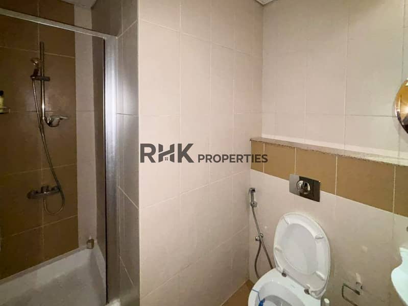 8 Modern apartment bathroom with bathtub, glass shower enclosure, toilet and tiled walls
