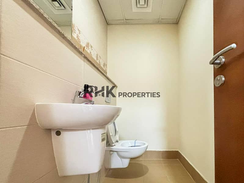 9 Compact apartment bathroom with white sink, toilet and tiled walls